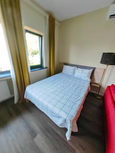 a bedroom with a bed and a red couch at Little Bucharest downtown apartments Romana in Bucharest