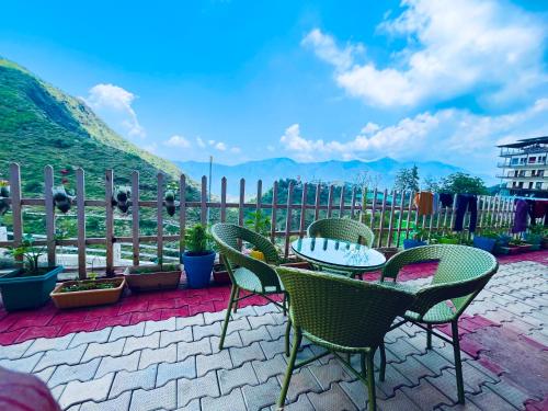 a patio with chairs and a table with a view at The Kempty Castle, Mussoorie in Mussoorie