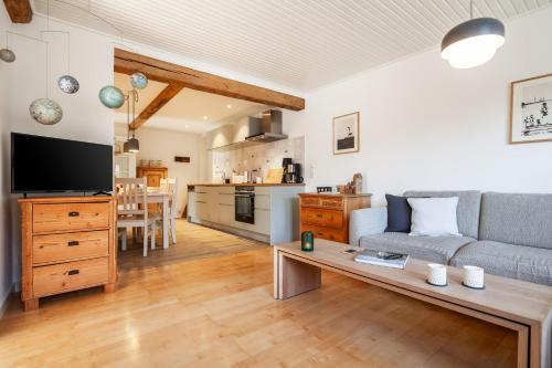 a living room with a couch and a table at Kurnkoomer in Alkersum