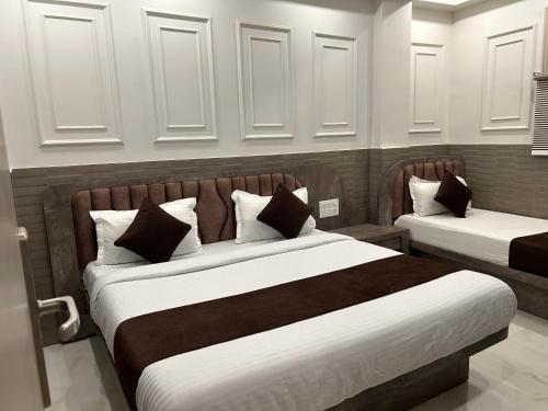 ニューデリーにあるHotel Sapphire International By ASR Hospitalityのベッドルーム1室(白と茶色のベッド2台付)