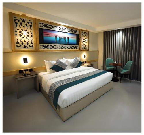 a hotel room with a large bed and a desk at Aroma Hotel in Aqaba