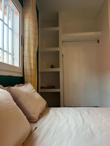 a bedroom with a white bed and a window at SteilaDay Hébergement 976 in Pamandzi