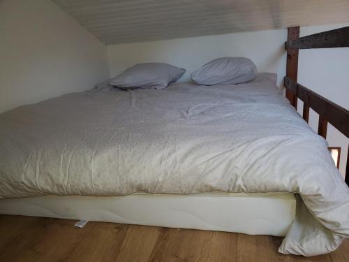 a large bed in a room with a wooden floor at Appartement entier - cosy et lumineux - Plein centre-ville in Épinal
