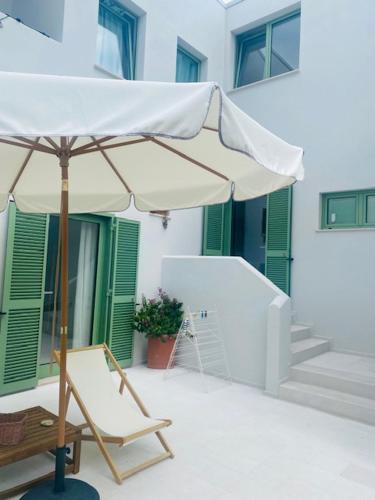 a white umbrella and a chair on a patio at Le villette in Vasto