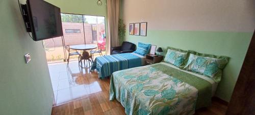 a bedroom with a bed and a tv and a table at Apê Estúdio Rodrigues 02 in Paranaíba