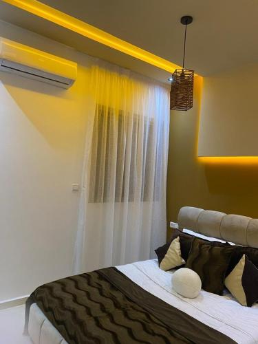 a bedroom with a large bed with a window at Appartement Moderne Vert in Kenitra