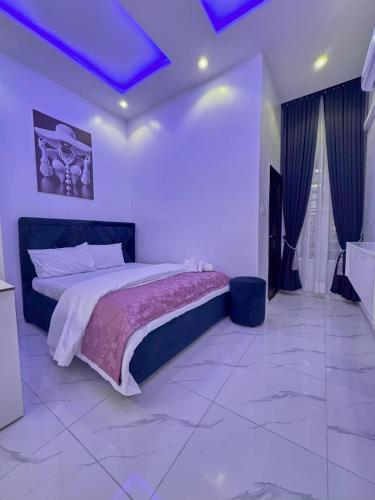 a bedroom with a large bed with a purple ceiling at luxury 3bed rooms duplex lekki Lagos nigeria in Lekki