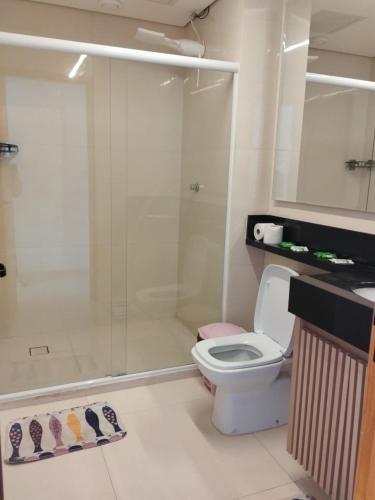 a bathroom with a toilet and a glass shower at Estilo Suíte in São Paulo