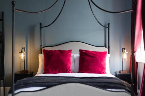 a bedroom with a bed with two red pillows at The Boat House Luxury Apartments Scarborough in Scarborough