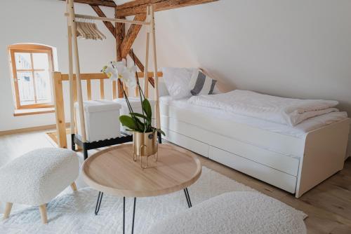 a bedroom with a bed and a table with flowers on it at Kaple Jinak in Vrchovany