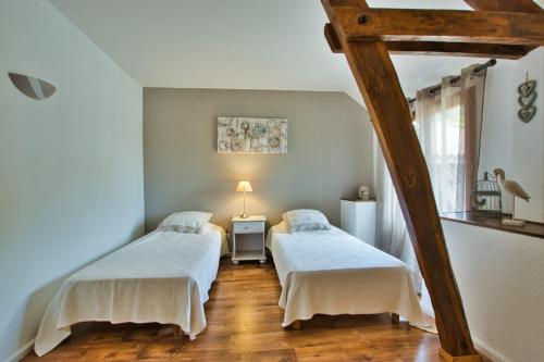 a bedroom with two beds and a table with a lamp at Grange authentique avec vue, piscine chauffée et Wifi in Daglan