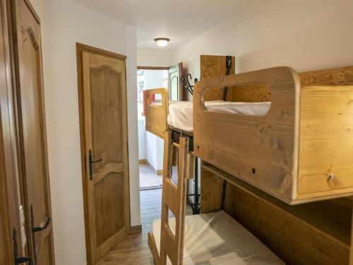 Cette chambre comprend 2 lits superposés et une porte. dans l'établissement Appartement cosy à Châtel, 100m des pistes, balcon, WiFi, parking, jusqu'à 4 personnes - FR-1-676-105, à Châtel