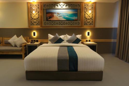 a bedroom with a large bed and a couch at Aroma Hotel in Aqaba
