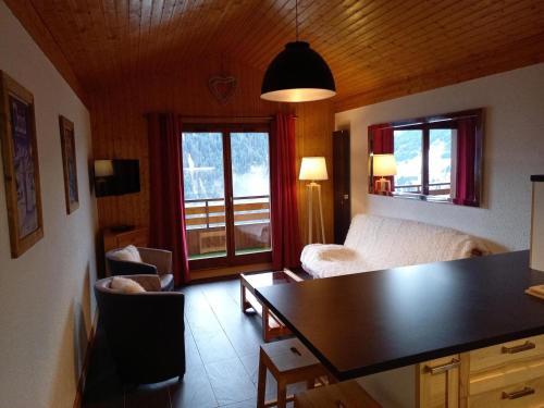un salon avec un canapé et une table dans l'établissement Chalet chaleureux à Châtel - Idéal 6 pers, 3 pièces, proche télésiège, WIFI, balcon sud, garage - FR-1-676-21, à Châtel