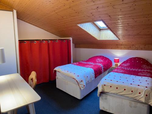 - une chambre mansardée avec 2 lits et une fenêtre dans l'établissement Chalet chaleureux à Châtel - Idéal 6 pers, 3 pièces, proche télésiège, WIFI, balcon sud, garage - FR-1-676-21, à Châtel