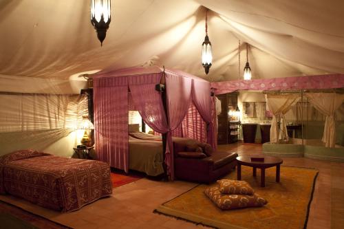 a bedroom with a tent with a bed and a couch at Kasbah Agafay Hotel & Spa in El Karia