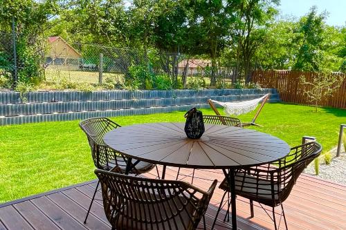 a table and chairs on a wooden deck at Natur Harmony Tiszafüred in Tiszafüred