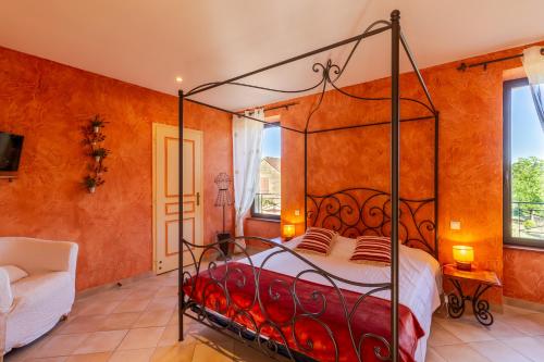 a bedroom with a metal bed in a room with orange walls at Chambre d'hotes Les Clauzels in Proissans