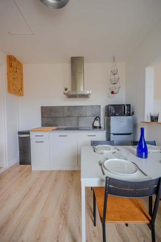 a kitchen with a white table and a blue vase at Charming house with garden, center of Puilboreau in Puilboreau