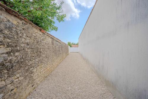 a stone wall next to a brick wall at Charming house with garden, center of Puilboreau in Puilboreau