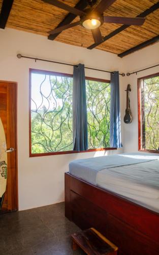 a bedroom with a bed and a large window at Four Trees Jungle Lodge in San Juan del Sur