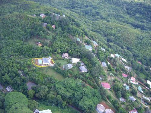 an aerial view of a village in a forest at Residence Monte-Cristo in Anse Boileau