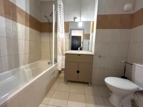 ein Badezimmer mit Badewanne, Toilette und Waschbecken in der Unterkunft Joli studio avec balcon vue mer à St Florent 140 in Saint-Florent