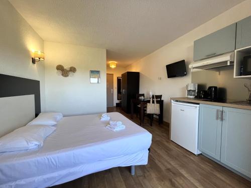 ein Hotelzimmer mit Bett und Küche in der Unterkunft Joli studio avec balcon vue mer à St Florent 140 in Saint-Florent