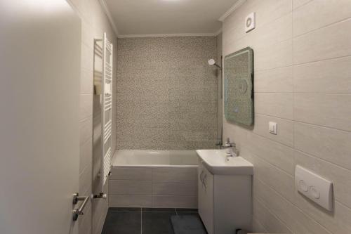 a bathroom with a tub and a toilet and a sink at Dominic Apartments Sighisoara in Sighişoara