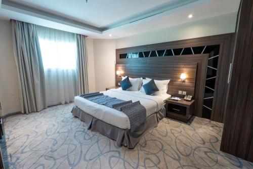a hotel room with a large bed and a window at Sumou Hotel Al Khobar in Al Khobar