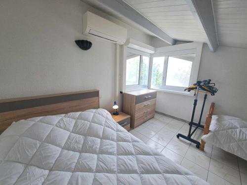 une chambre avec un grand lit blanc et une fenêtre dans l'établissement Appartement 2P Mezzanine, Grande Terrasse, Clim, Accès Direct Plage, Parking Privé - FR-1-326-831, à Marseillan