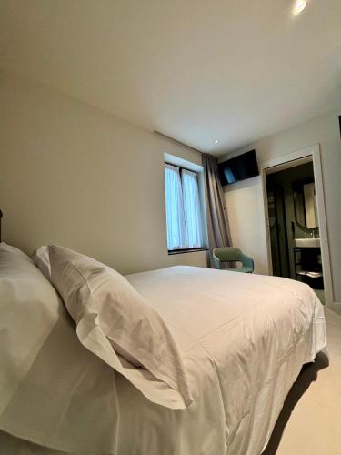 a bedroom with a white bed and a window at Hotel Stelvio Tirano in Tirano