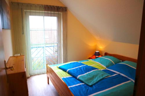 a bedroom with a bed and a large window at Seebrise 25 in Funfseen