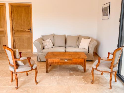 a living room with a couch and two chairs and a coffee table at Radegonde - Maison de charme avec piscine in Rustrel
