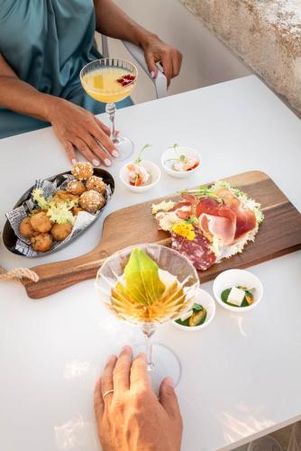 a person sitting at a table with plates of food at Masseria Auraterrae in Polignano a Mare