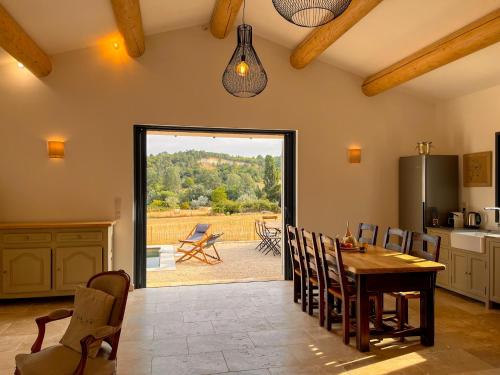 a kitchen with a table and chairs and a patio at Radegonde - Maison de charme avec piscine in Rustrel