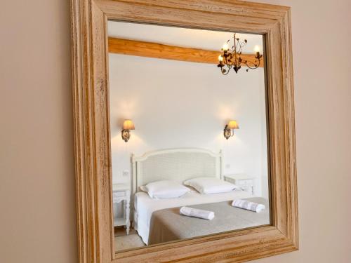 a mirror reflecting a bedroom with a bed at Radegonde - Maison de charme avec piscine in Rustrel
