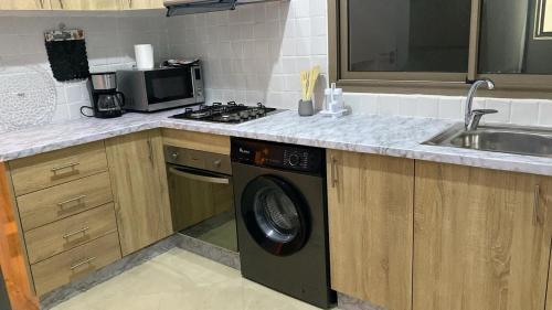 a kitchen with a sink and a washing machine at Appartement Orientale in Kenitra