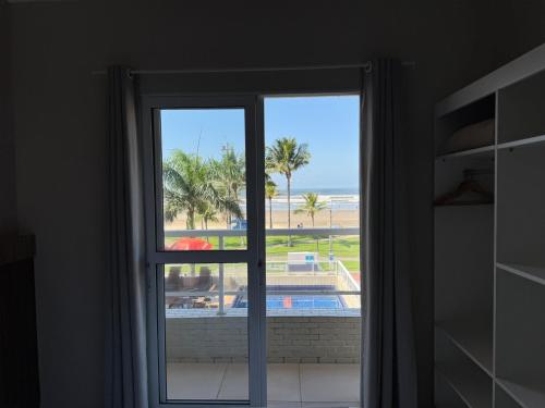 a window with a view of the beach at Pousada Cantinho Oriental in Bertioga