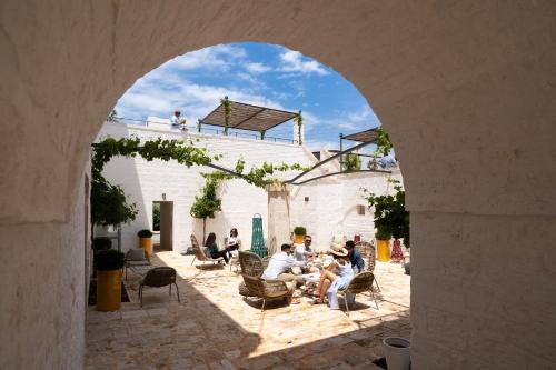 a group of people sitting in chairs in an archway at Masseria Auraterrae in Polignano a Mare
