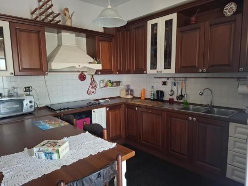 a kitchen with wooden cabinets and a table in it at La Casa di Piero in SantʼAngelo