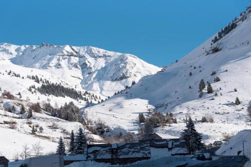 a snow covered mountain with a town in the foreground at Barèges T2 Rando Cure in Barèges