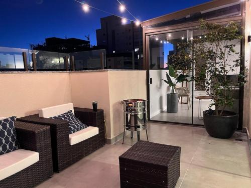 a balcony with wicker chairs and a table on a building at Cobertura 2Dorm Vista Mar e Serra in Capão da Canoa