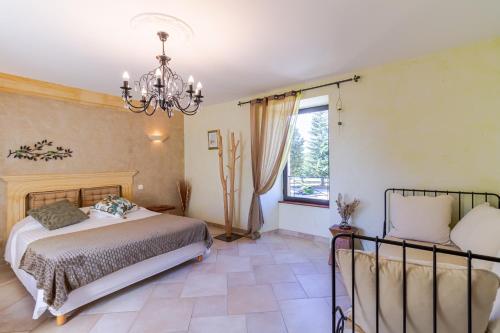 a bedroom with a bed and a chandelier at Chambre d'hotes Les Clauzels in Proissans