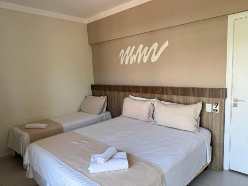 a bedroom with two beds with towels on them at Pousada Cantinho Oriental in Bertioga