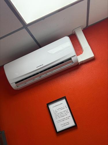 a device on a wall with a tablet next to it at Peace & Love Hostel in Paris