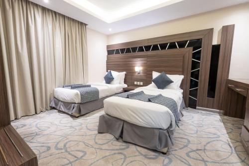 a hotel room with two beds in a room at Sumou Hotel Al Khobar in Al Khobar