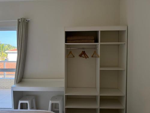 a white book shelf in a room with a bed at Pousada Cantinho Oriental in Bertioga