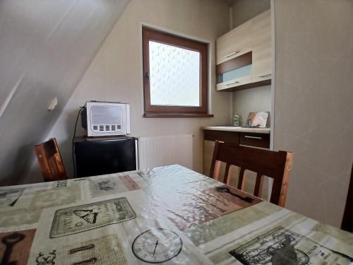 Una pequeña cocina con una mesa y una ventana. en GolfSPA Golfowa Wioska, en Szczytna