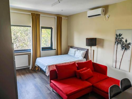 a bedroom with a bed and a red couch at Beautiful new studios&apartments super central location in Bucharest